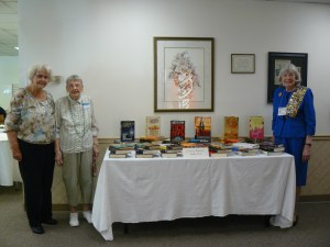 Member LaVonne Waldren with 2 library representatives with her book donation.